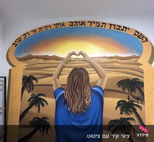 ציור קיר של אישה במדבר עם שקיעה